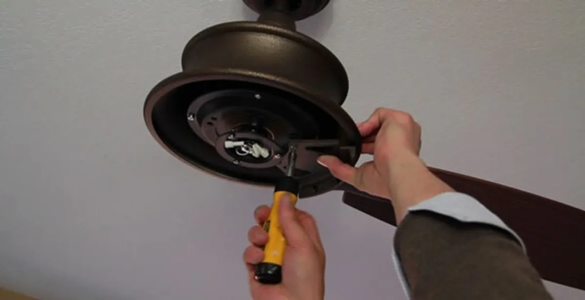 Electrician installing ceiling fan mounting bracket and fixture in West Palm Beach, FL