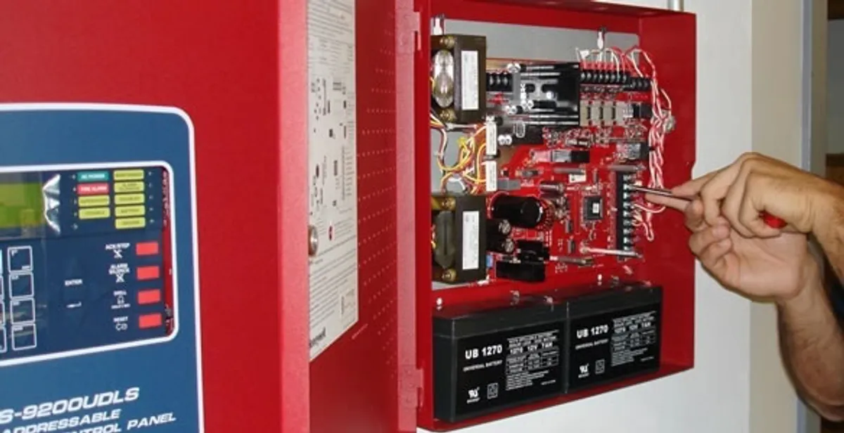 fire alarm installation service showing technician configuring fire alarm control panel in West Palm Beach, FL