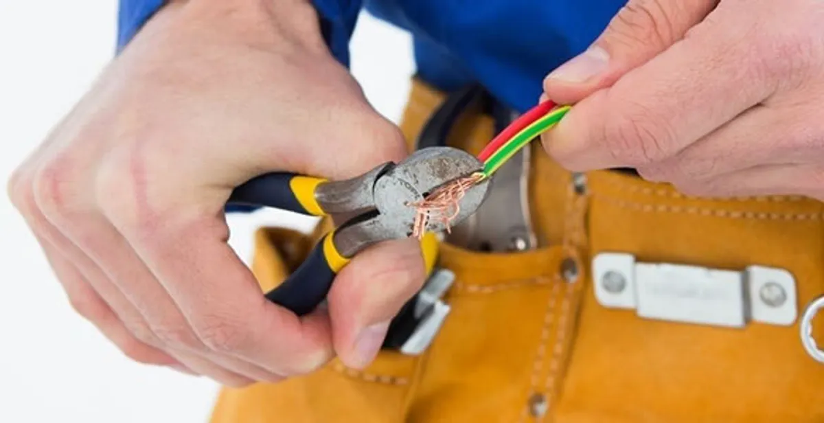licensed electrician securing electrical wiring with professional tools during service work in West Palm Beach, FL