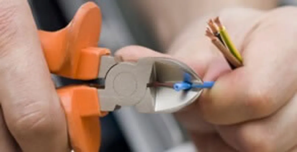 licensed electrician performing precise wire cutting and preparation during electrical service in West Palm Beach, FL